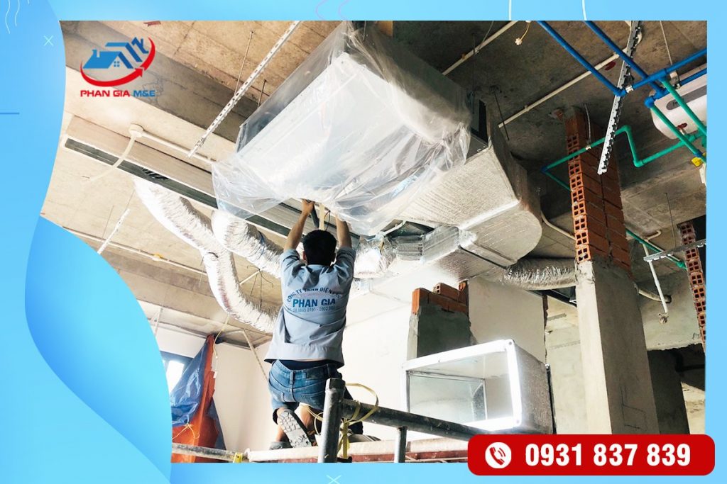 Kỹ thuật viên đang lắp đặt dàn nóng điều hòa giấu trần